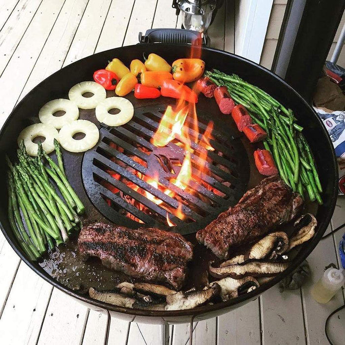 A close-up view of an Arteflame grill grate insert on a Weber grill, with steaks and vegetables cooking evenly over the flames.