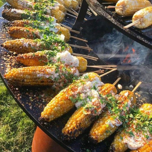 Grilled corn on the Arteflame Classic 40" Grill, showcasing the grill's versatility.