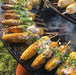 Grilled corn on the Arteflame Classic 40" Grill, showcasing the grill's versatility.