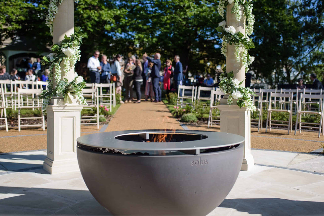 Solus Decor Hemi Firebowl adding a touch of elegance to an outdoor wedding venue, with a delicate flame enhancing the ceremonial ambience.
