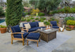 The Tortuga Outdoor 6-Piece Indonesian Teak Sofa and Fire Table Set - Canvas Natural or Navy is a luxurious patio furniture set featuring blue cushions and a fire pit.