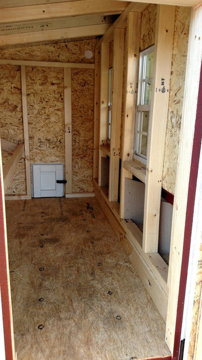 Spacious interior of the Large OverEZ Chicken Coop, showcasing nesting boxes and the wooden frame, in a classic red and white color scheme.