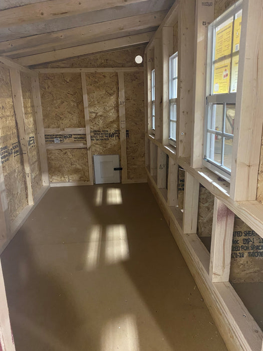 The interior of an OverEZ XL Chicken Coop, showcasing the expansive and empty space ready to house up to 20 chickens, with ample lighting and sturdy wooden construction.
