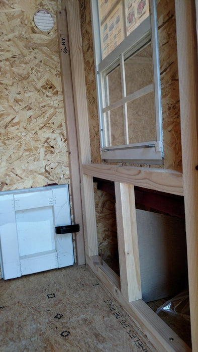 Interior design of a small OverEZ chicken coop showing the window and door, with attention to comfort and ventilation.