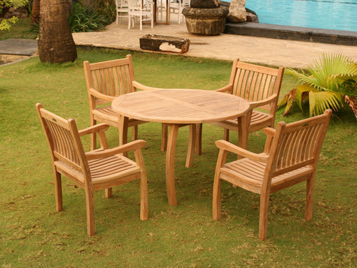 A Tortuga Outdoor Jakarta 5-Piece Dining Teak Set featuring a wooden dining table and chairs, perfect for all-weather use in front of a pool.
