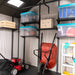 A Lifetime 11 Ft. X 11 Ft. Outdoor Storage Shed - 6433 with a lawn mower and other items.