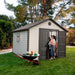 A woman is opening the door of a Lifetime 11 Ft. X 11 Ft. Outdoor Storage Shed - 6433.