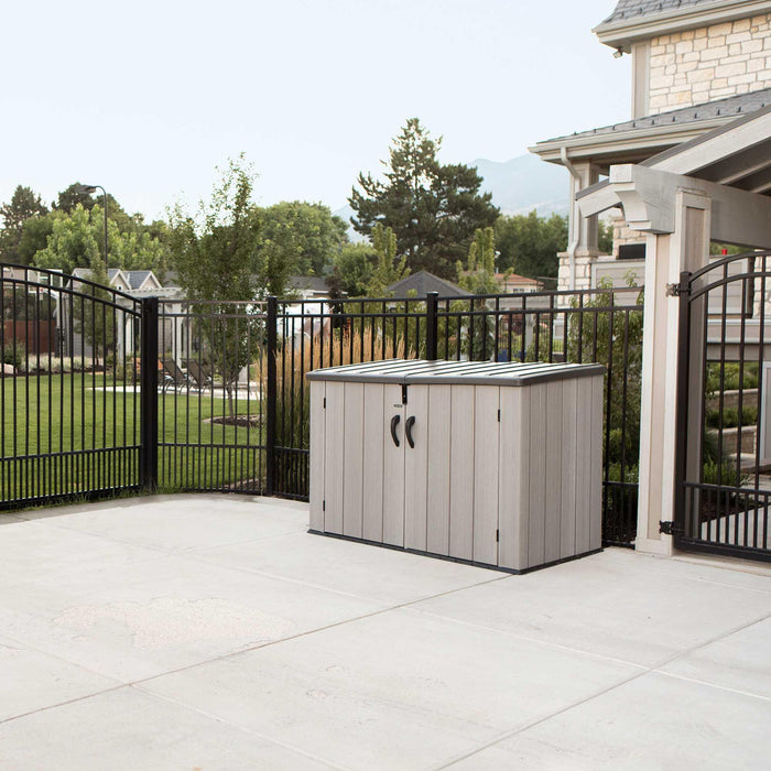 A backyard with a fence and a Lifetime Horizontal Storage Shed - 60296U.