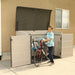 A boy standing next to a Lifetime Horizontal Storage Shed (75 Cubic Feet) - 60170 in a storage shed.