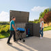 A man and woman pushing a stroller in front of a Lifetime Horizontal Storage Shed (75 Cubic Feet) - 60341.
