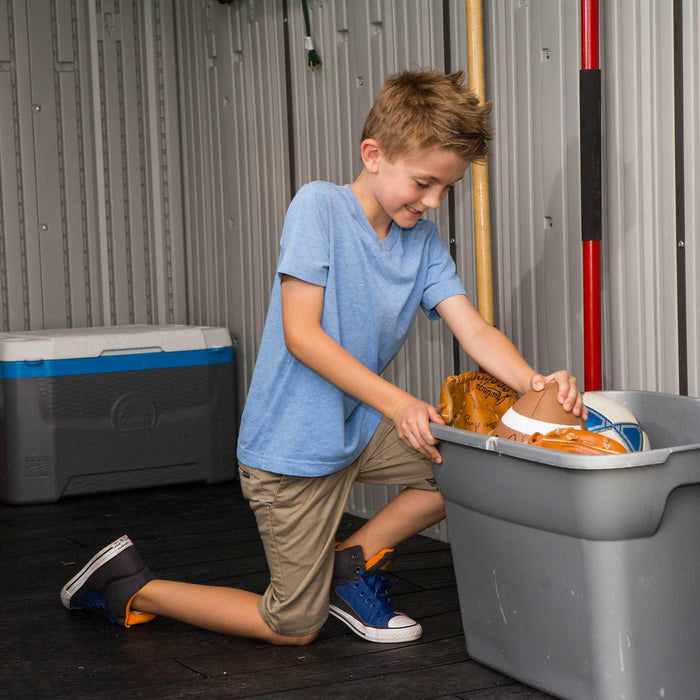 A young boy interacting with items in a storage cabin 