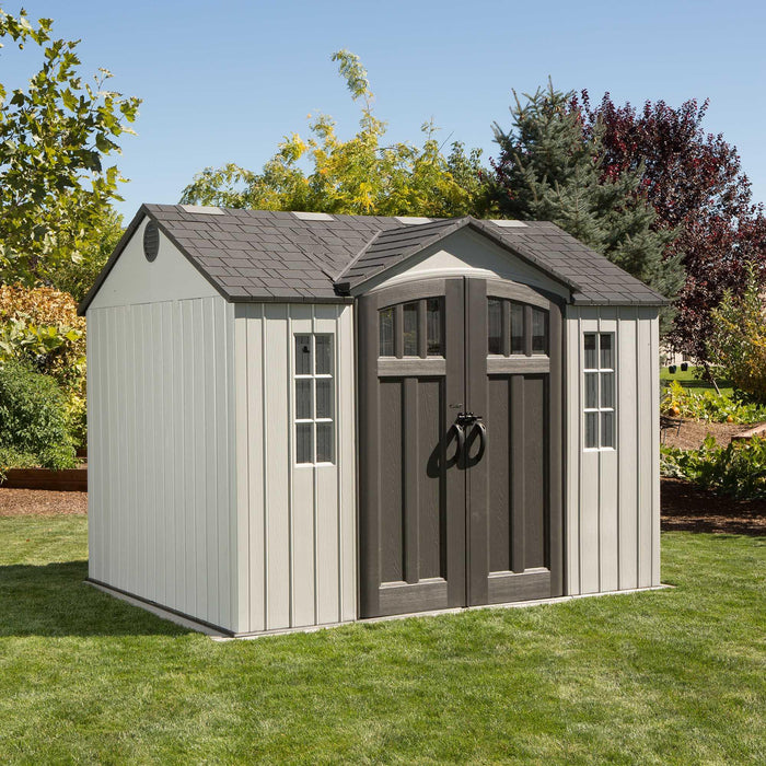 A gray and white Lifetime 10 Ft. X 8 Ft. Outdoor Storage Shed - 60243 on a green lawn.