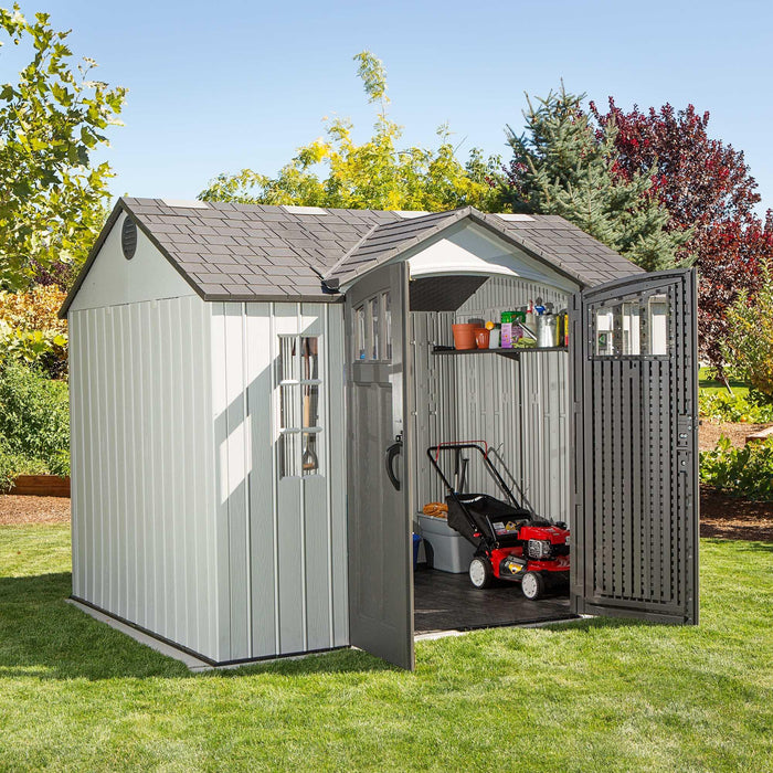 A gray Lifetime 10 Ft. X 8 Ft. Outdoor Storage Shed - 60243 with a lawn mower in it.