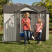 A woman and a girl standing next to a Lifetime 10 Ft. X 8 Ft. Outdoor Storage Shed - 60243.