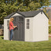 A woman standing in front of a Lifetime 10 Ft. X 8 Ft. Outdoor Storage Shed - 60243.