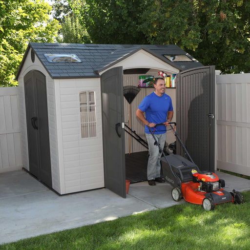 A man pushing a lawn mower out of the open Lifetime 10 Ft. X 8 Ft. Outdoor Storage Shed