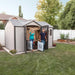 Two people standing in front of a Lifetime 12.5 Ft. X 8 Ft. Outdoor Storage Shed - 60223.