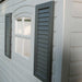A Lifetime 15 Ft. X 8 Ft. Outdoor Storage Shed - 6446 with shutters on the side of a house.