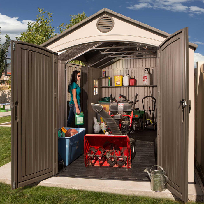 A woman in a Lifetime 15 Ft. X 8 Ft. Outdoor Storage Shed - 60079.