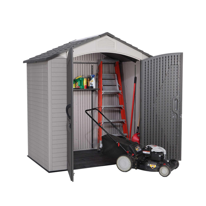 An angled view of a small shed with doors opened revealing a lawn mower and a ladder.