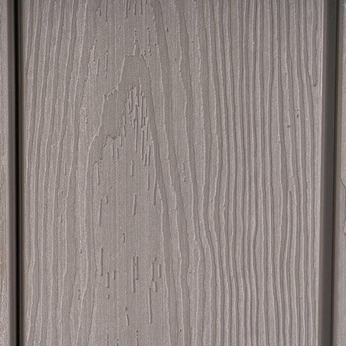 A close up view of a gray wood siding of a shed