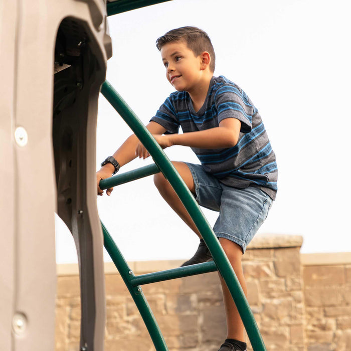 A child actively climbing on the green ladder of the Lifetime Double Adventure Tower with Monkey Bars.