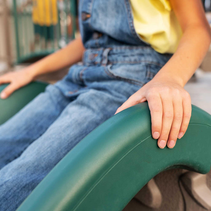 Close-up of a child's hands holding onto a green slide of the Lifetime Double Adventure Tower.