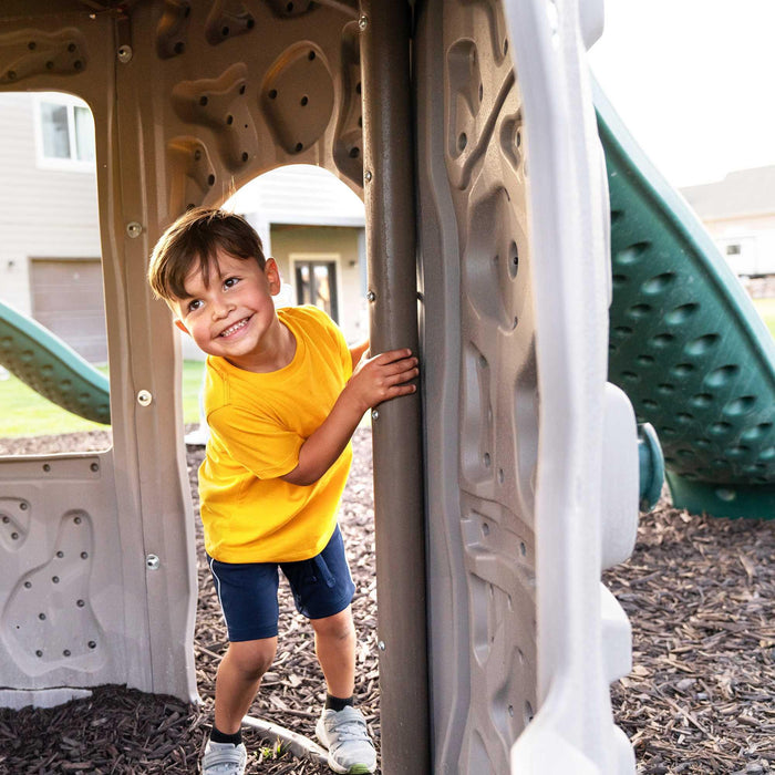 A young boy smiling while playing inside the Lifetime Double Adventure Tower With Monkey Bars.