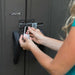 A woman unlocking a door with a Lifetime 10 Ft. X 8 Ft. Outdoor Storage Shed - 60118 key.