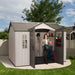 A woman is standing in front of a Lifetime 10 Ft. X 8 Ft. Outdoor Storage Shed - 60118.
