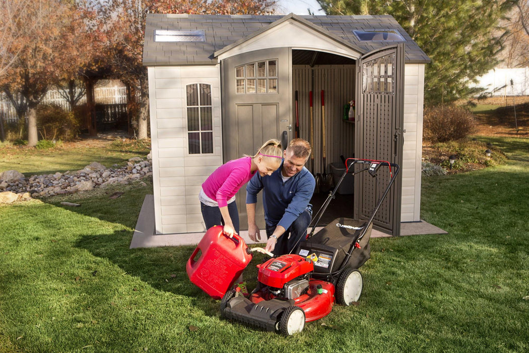 A man and a woman putting a Lifetime 10 Ft. X 8 Ft. Outdoor Storage Shed - 60178 in a shed.