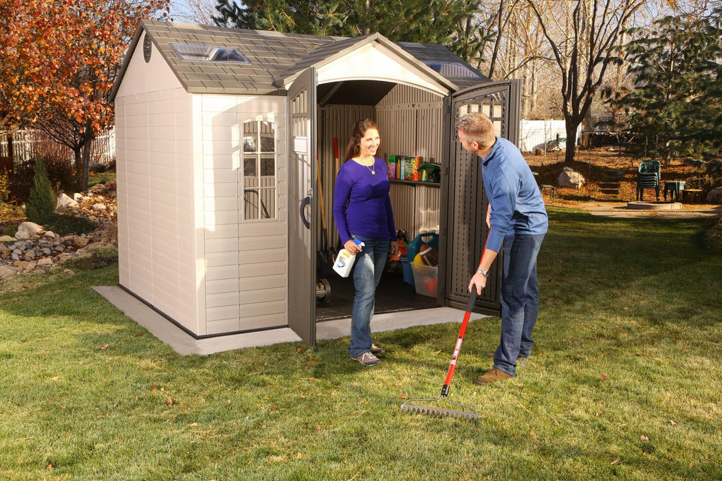 Two people standing in front of a Lifetime 10 Ft. X 8 Ft. Outdoor Storage Shed - 60178.