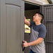 A man opening the door of a Lifetime 11 Ft. X 18.5 Ft. Outdoor Storage Shed - 60355 shed.