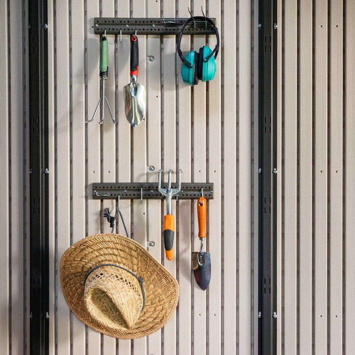 Lifetime hats and gardening tools are hanging on the wall of a Lifetime shed.