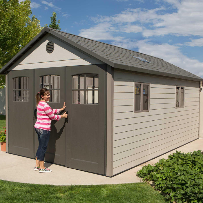 A woman standing in front of a Lifetime 11 Ft. X 18.5 Ft. Outdoor Storage Shed - 60236.