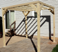 An Amish Gazebos wooden pergola on a patio in front of a house.