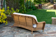 Back view of the Tortuga Outdoor Sea Pines - Mojave loveseat on a stone patio.