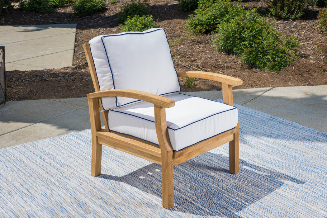 A durable Tortuga Outdoor teak outdoor chair set with Sunbrella Canvas Natural or Navy cushions on a blue rug.