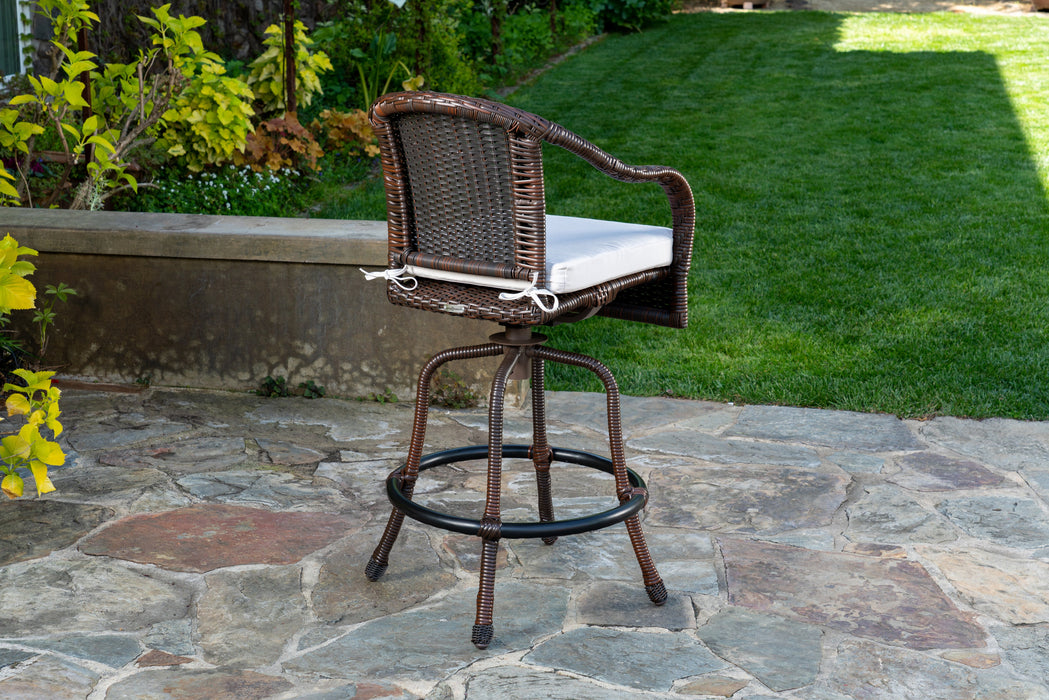 A Tortuga Outdoor Sea Pines 3-Piece Wicker Bar Set - Java or Mojave on a stone patio, part of an Outdoor Wicker Furniture Set.