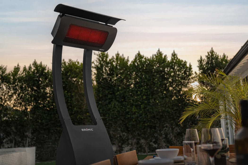 A luxurious outdoor dining experience at dusk with Bromic Tungsten 500 Series heaters adding warmth and ambiance to the setting.