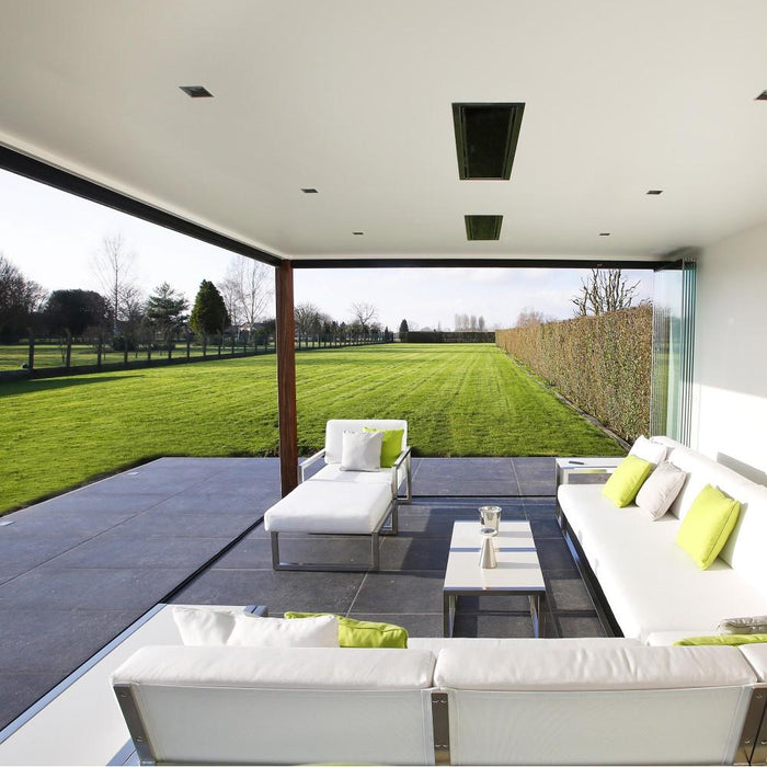 Luxury outdoor seating area heated by Bromic Platinum Smart-Heat 4500W electric heaters overlooking a lush green lawn.