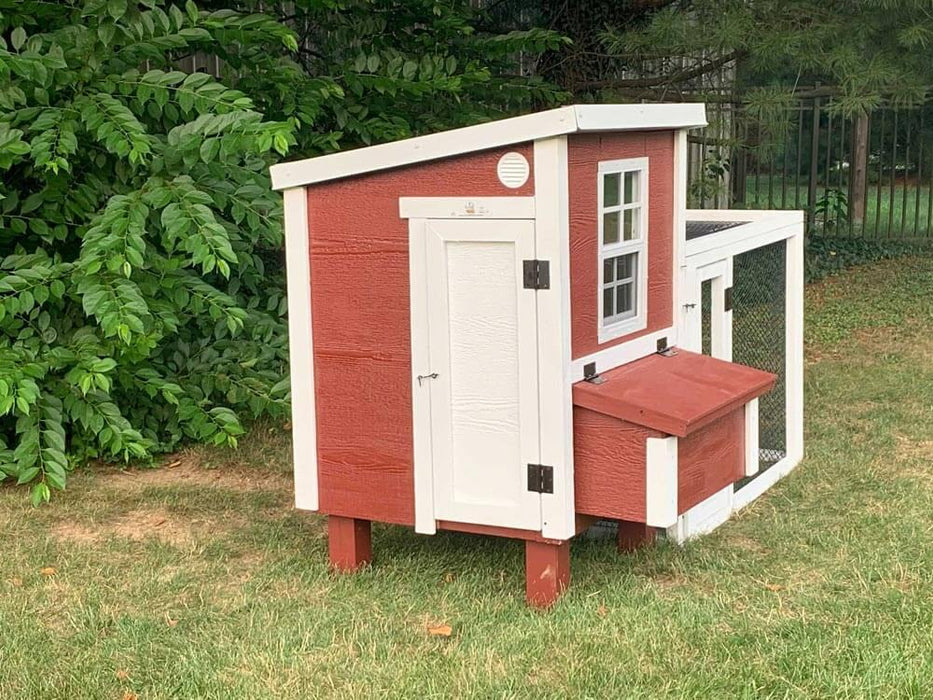 Angled view of OverEZ Chicken Coop with red and white color scheme showing the accessible door, designed to accommodate up to 5 chickens.