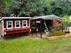 The OverEZ Chicken Coop XL Flock Bundle set against a verdant garden backdrop with a walk-in run and vibrant flower bed.