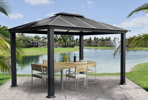 Santa Monica Hard Top Gazebo set up for dining with a modern outdoor table and chairs overlooking a peaceful lake.
