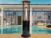 Black Helios Flame Tower Heater by a poolside, with remote control and five-stage burner details.