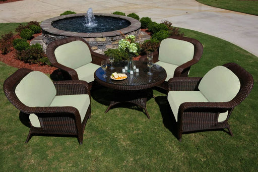A Tortuga Outdoor Sea Pines 5-Piece Outdoor Wicker Conversation Set - Java, with seating cushions, placed in a patio yard.