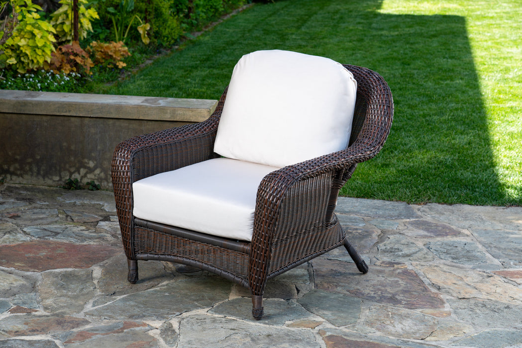 The club chair from the Tortuga Outdoor Sea Pines 5-Piece Outdoor Wicker Conversation Set - Java on a patio