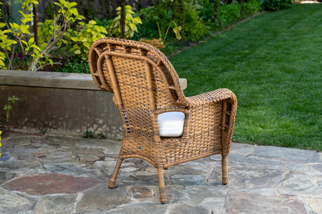 Back view of the chair of the Tortuga Outdoor Sea Pines 5-Piece Outdoor Wicker Dining Set - Mojave  on a stone patio.