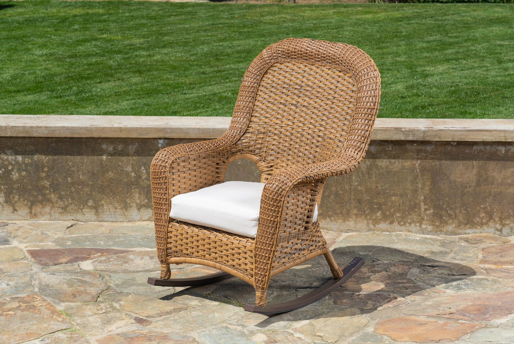 Full view of the chair from the Tortuga Outdoor Sea Pines 3-Piece Wicker Rocking Chair & Table Set Mojave, gracing a beautiful stone patio.