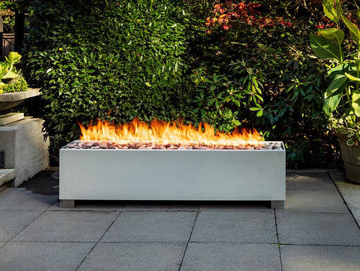 Outdoor Solus Decor Fire Pit with 108,000 BTU Linear Burner in Garden Setting.